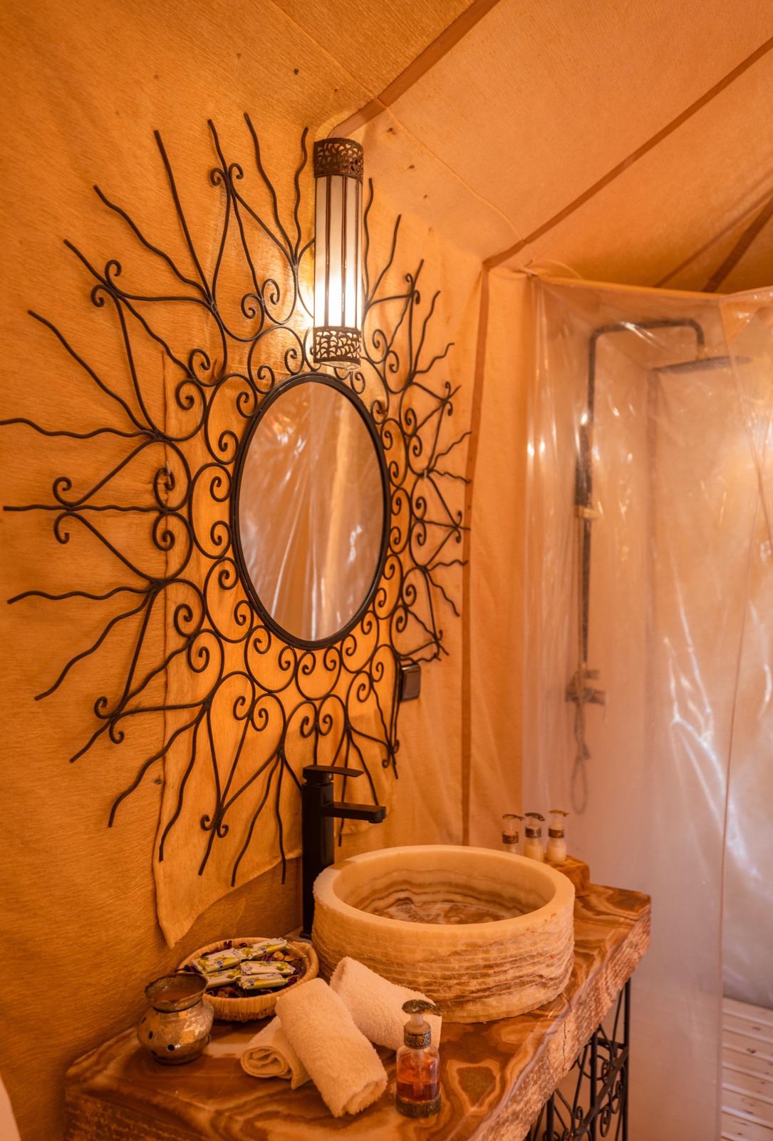 Baño privado con lavabo de ónix en jaima de lujo