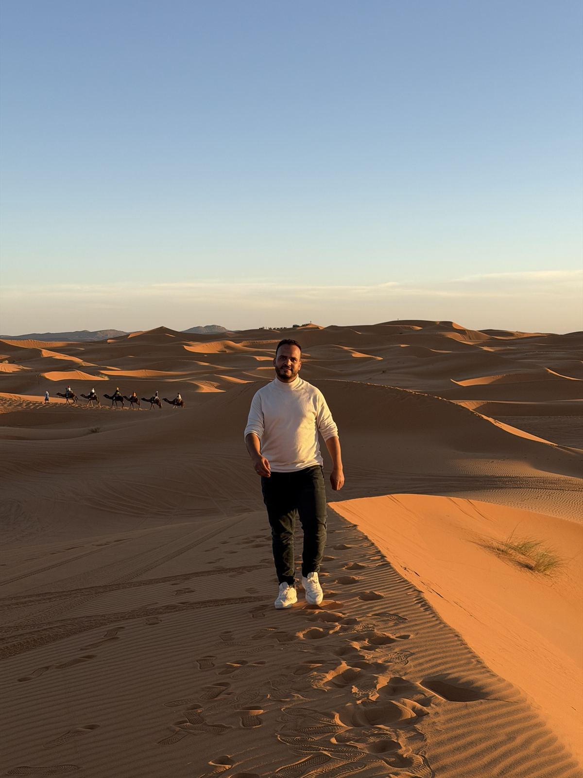 Caravana de dromedarios en las dunas de Erg Chebbi, Merzouga, al atardecer