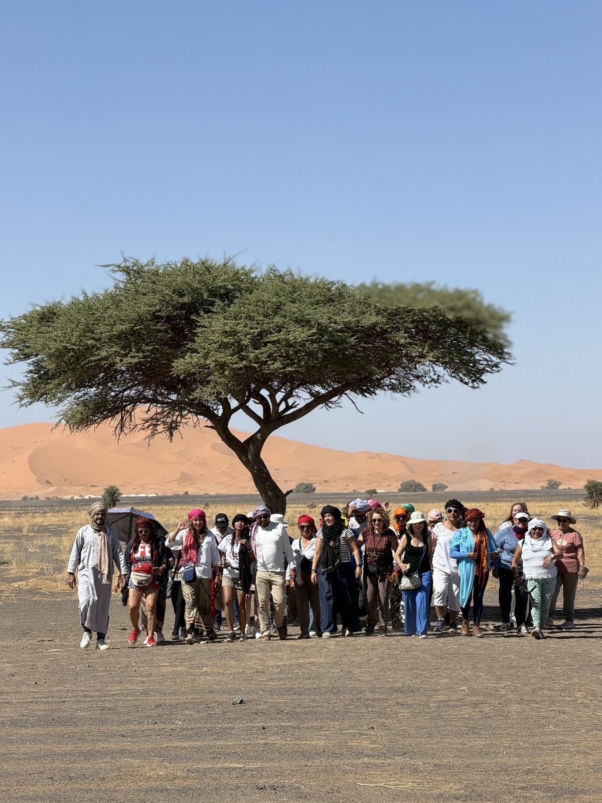 Grupo de viajeros caminando hacia las dunas de Merzouga